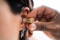 Doctor Inserting Hearing Aid In Woman's Ear Royalty Free Stock Photo