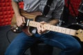 Cropped image of electric guitar player in soundproof studio