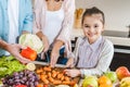 cropped image of family at kitchen little kid with mother slicing vegetables and looking