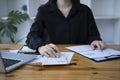 Female accountant using calculator and checking financial reports. Royalty Free Stock Photo