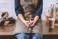 Female artist sitting on table and holding brushes