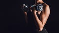 cropped image of female bodybuilder working out with dumbbells black