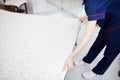 A female chambermaid making bed in hotel room Royalty Free Stock Photo