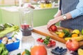 Cropped image of female cook cutting fruit on board preparing smoothie in kitchen Royalty Free Stock Photo