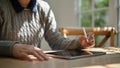 Cropped image of a female in cozy sweater working on her tasks on her digital tablet Royalty Free Stock Photo