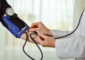 Cropped image of Female doctor checking blood pressure of patient at table