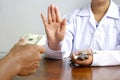 female doctor`s hand refusing to take bribe from patient man at doctor office Royalty Free Stock Photo