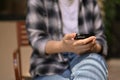 Cropped image of a female sits at a chair and uses her smartphone. chat, text, message Royalty Free Stock Photo