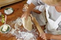 Cropped image of a female and kid hands holding dough in heart shape top view. Baking ingredients on the wooden table Royalty Free Stock Photo