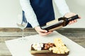 Cropped image Female sommelier looking at bottle of white wine and holding it