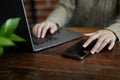 Cropped, A female working on her laptop while using her smartphone at the table Royalty Free Stock Photo