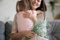 Cropped image focus on flowers, excited young mother cuddling daughter. Royalty Free Stock Photo