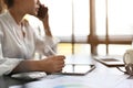 Asian businesswoman talking on the phone while using digital tablet at her desk Royalty Free Stock Photo