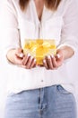 Cropped image of a girl in jeans and a T-shirt holding a red flower in her hands with a manicure on a white background Royalty Free Stock Photo