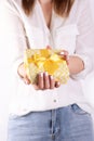 Cropped image of a girl in jeans and a T-shirt holding a red flower in her hands with a manicure on a white background Royalty Free Stock Photo