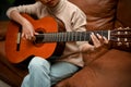 Cropped image, A gorgeous young Asian female playing guitar in her home living room Royalty Free Stock Photo