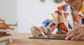 A cropped image of a graphic designer is using a tablet at the wooden working desk Royalty Free Stock Photo