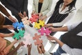 Cropped image of group of men and women standing in circle and connecting colored puzzle pieces. Royalty Free Stock Photo