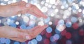 Cropped image of hands against glowing bokeh Royalty Free Stock Photo