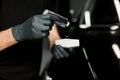 Cropped image of hands of male auto service worker in protective gloves, applying special polish cream, nano-ceramic