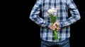 Cropped image hands of man behind his back with bouquet of wild flowers. Surprise, gift for your loved one, woman`s day, valentin