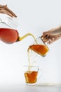 cropped image of hands pouring tea from teapot in cups Royalty Free Stock Photo