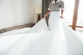 Cropped image of a hotel maid changing bed sheet