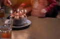 Cropped image of little asian boy blowing candles while three generation family celebrating her birthday Royalty Free Stock Photo