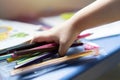 Cropped image of a little child hand holding a colorful pencils, playing children using pencil crayons at table indoors Royalty Free Stock Photo