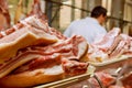 Cropped image of male butcher cutting raw meat with knife at counter in shop Royalty Free Stock Photo