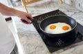 Cropped image of man cooking scrambled eggs on frying pan Royalty Free Stock Photo