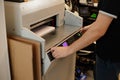 Cropped image man hands using paper cutter machine, guillotine offset. Manufacturing. Control panel, laser cut level. Royalty Free Stock Photo