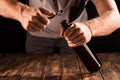cropped image of man opening beer bottle by opener at wooden