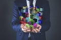 Man presenting multiple cubes in hands