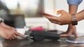 Cropped image of man using a smartphone for making a bill payment at credit card reader . Royalty Free Stock Photo