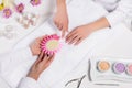 cropped image of manicurist holding samples of nail varnishes while woman