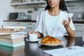 Cropped image of mixed race girl in white robe holding smartphone and cup of coffee in morning Royalty Free Stock Photo