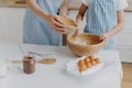 Cropped image of mothers and daughters hands mixing ingredients to prepare dough and bake tasty pastry, stand near kitchen table Royalty Free Stock Photo