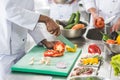 cropped image of multicultural chefs cutting and washing vegetables