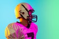 Cropped image of one American football player in sports equipment helmet and gloves isolated on blue studio background Royalty Free Stock Photo