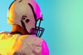 Cropped image of one American football player in sports equipment helmet and gloves isolated on blue studio background Royalty Free Stock Photo