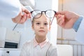 cropped image of ophthalmologist wearing new glasses on pre-adolescent child