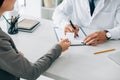 cropped image of patient giving id card to doctor to fill insurance claim form