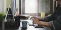 Cropped image of photographer hands typing on wireless keyboard and using mouse while sitting in front computer monitor. Royalty Free Stock Photo