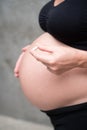 Cropped image of pregnant woman in black leggins and bra holding medicine