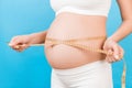 Cropped image of pregnant woman in white underwear measuring her abdomen to check baby development. Centimeter tape measure at Royalty Free Stock Photo
