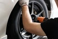 Cropped image of profession mechanic repairing car`s tire in automobile shop