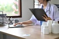 Professional Asian female doctor concentrating on her medical research, using laptop Royalty Free Stock Photo