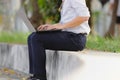 Cropped image of relaxed young Asian business man working with laptop at public park. Royalty Free Stock Photo