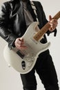 Cropped image of rock musician posing with white guitar indoor. Vertical. Royalty Free Stock Photo